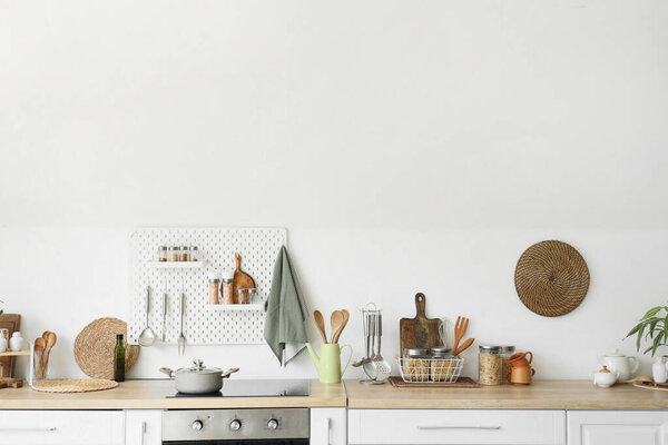 Счетчики и пегборды с посудой на светлой стене на кухне