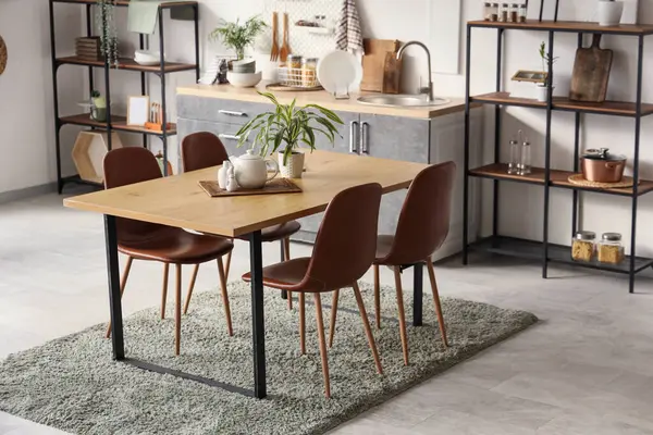 Mutfağın içinde yemek masası ve bitkiler var.