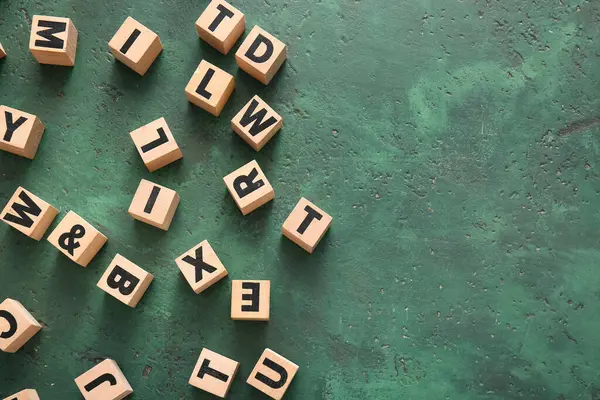 Yeşil arkaplanda İngilizce harfleri olan küpler