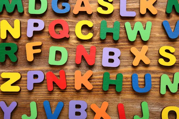 Ahşap arka planda birçok İngilizce harf