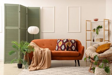 Rahat kahverengi kanepesi, katlanır perdesi ve çiçekli modern oturma odası.