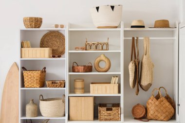 Sepet, şapka ve kitaplarla dolu bir dolap.