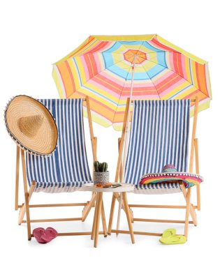 Renkli plaj şemsiyeli çizgili güverte sandalyeleri ve beyaz arka planda izole edilmiş seyahat aksesuarları.