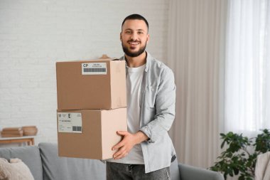Young man with parcel boxes at home
