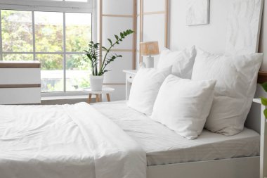 Beyaz çarşaflı ve katlanabilir ekranlı aydınlatma odasının içinde.