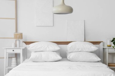 Yatak ve masaların üzerinde beyaz çarşaf olan aydınlatma odasının içinde.