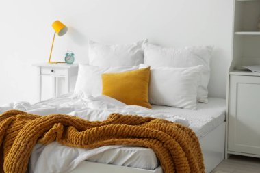 Yatak ve masa üzerinde beyaz çarşaf olan aydınlık odanın içinde.