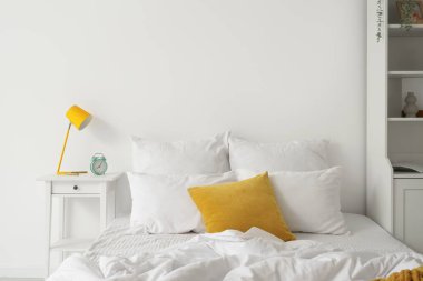 Yatak ve masa üzerinde beyaz çarşaf olan aydınlık odanın içinde.