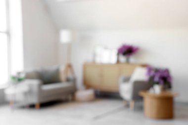 Kanepesi, koltuğu ve vazolarında leylak çiçekleri olan bulanık oturma odası manzarası