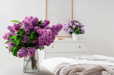 Vazodaki yumuşak bankta leylak çiçekli vazo.