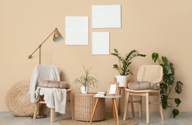 Oturma odasının içindeki bej duvarın yanındaki kahve masası, sandalyeler ve bitkiler.