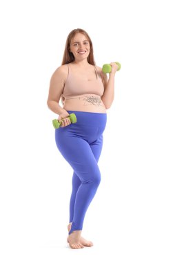 Beyaz arka planda dambılları olan hamile bir kadın.