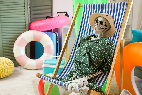 Oturma odasındaki güverte sandalyesinde insan iskeleti.