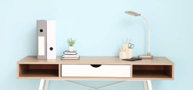 Masa lambası ve ofis malzemelerinin bulunduğu modern işyeri.