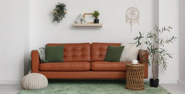 Kahverengi deri kanepe ve yumuşak puf ile modern oturma odası.