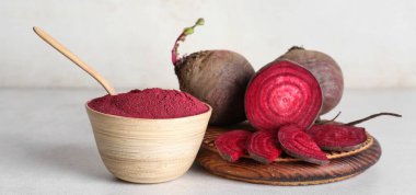 Tahta kase canlı pancar tozu ve beyaz arka planda taze pancar.