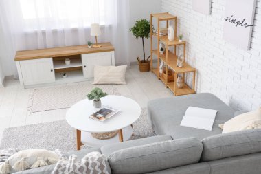 Rahat kanepe, bank, sehpa ve raf ünitesi olan şık bir oturma odası.