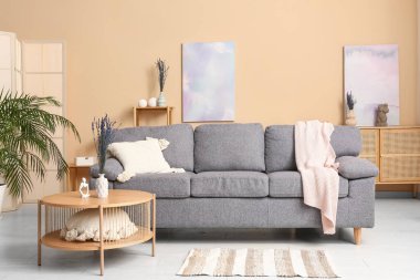 Ahşap masa üzerinde güzel lavanta çiçekleri olan modern oturma odasının şık bir iç mekanı.