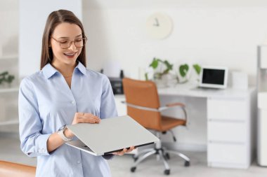 Güzel sekreter ofiste dizüstü bilgisayar açıyor