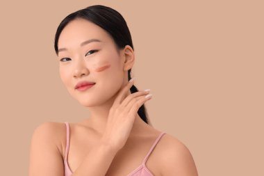 Güzel Asyalı kadın bej arka planda tonsal temel örnekleri ile