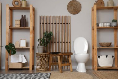 Tuvaleti, masası ve raf ünitesi olan bir tuvalet.