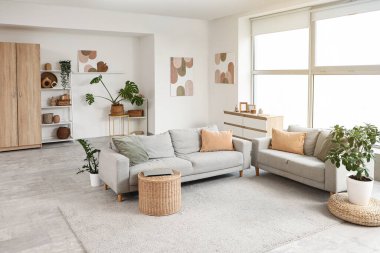 Oturma odasının içinde kanepeler, masa ve modern dizüstü bilgisayarlar.