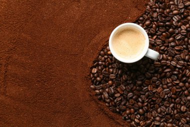 Kahve tozu, kavrulmuş fasulye ve bir fincan sıcak içecek karışımı.