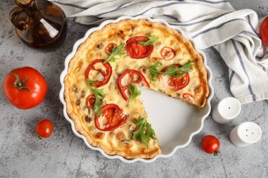 Gri arka planda roka yapraklı lezzetli domates tartı.