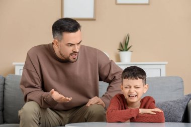 Baba evde ağlayan oğluyla kavga ediyor.