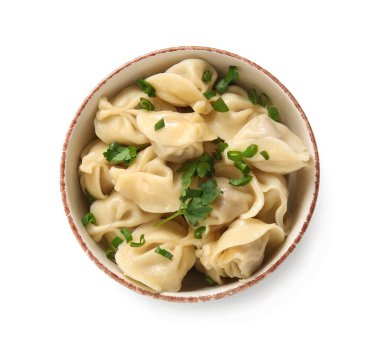 Bir kase lezzetli kaynamış hamur köftesi maydanozlu ve beyaz arka planda yeşil soğanlı.