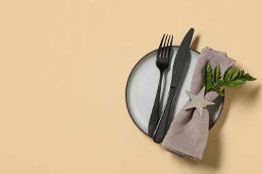 Siyah çatal bıçak takımı ve sarı arka planda taze yaprak ile güzel bir masa.