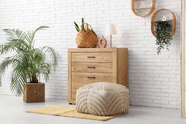 Hasır sepetlerde klozet, raflar ve bitkilerle dolu bir oda.