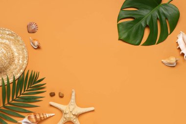 Turuncu arka planda şapka, deniz kabukları ve tropikal yapraklardan yapılmış çerçeve