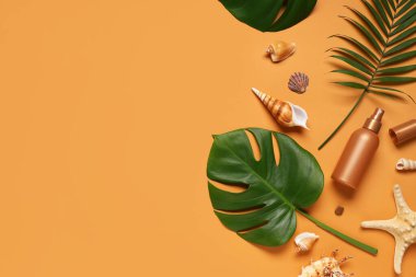 Turuncu arka planda güneş kremi, deniz kabuğu ve tropikal yapraklı yaz kompozisyonu