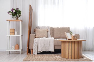 Ahşap sehpa, raf ünitesi ve oturma odasının içindeki kanepe.