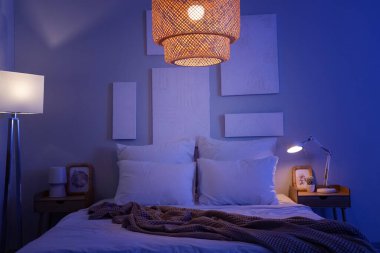 Karanlık yatak odasının içinde resimler ve parlayan lambalar var.