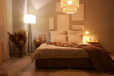 Karanlık yatak odasının içinde resimler, otlar ve parlayan lambalar var.