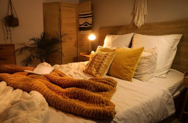 Koyu renk yatak odasının içinde katlanan bir ekran ve parlayan bir lamba.