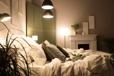 Yatak odasının içinde katlanan ekran, şömine ve geceleri parlayan lambalar.