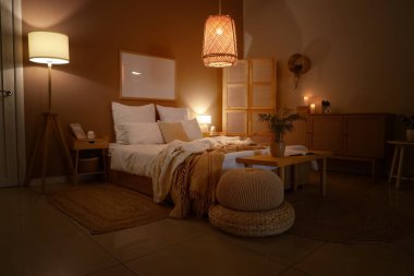 Katlanan perdeli, banklı ve parlayan lambalı karanlık yatak odasının içi.