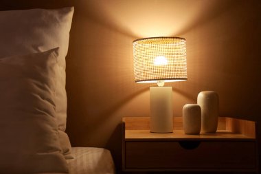 Karanlık yatak odasındaki dekorlu parlak lamba.