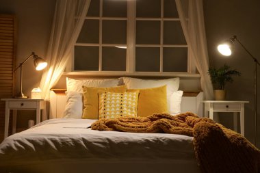 Pencereli, masalı ve ışıklı karanlık yatak odasının içi.