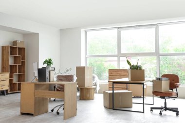 Taşındığı gün yeni ofiste içinde eşyalar ve mobilyalar olan kutular.