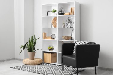 Kitaplığı, bitkileri ve koltuğu olan ışık odasının içi