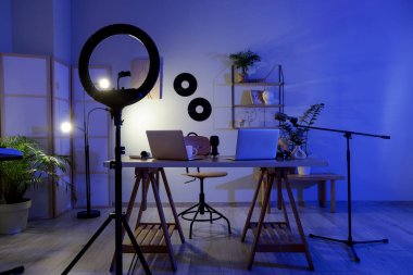 Karanlık Podcaster 'ın atölyesinin içinde iş yeri ve parlayan lamba var.