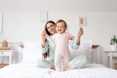 Mutlu anne ve bebeği yatak odasında.