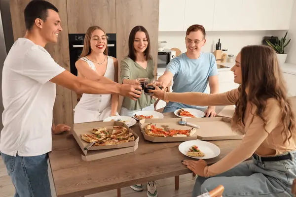 Pizzalı bir grup genç arkadaş ev partisinde içki içiyor.