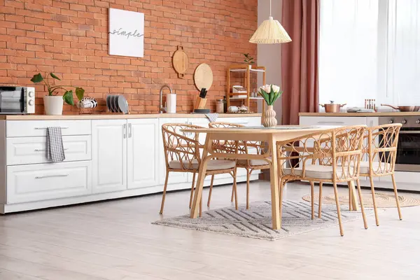 Tezgahı ve yemek masası olan modern mutfağın içi.