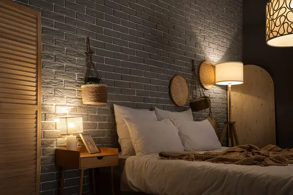 Masası, bitkileri ve parlayan lambaları olan karanlık bir yatak odası.