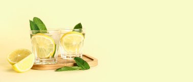 Arkaplanda soğuk mojito, limon ve nane içeren ahşap bir tahta.